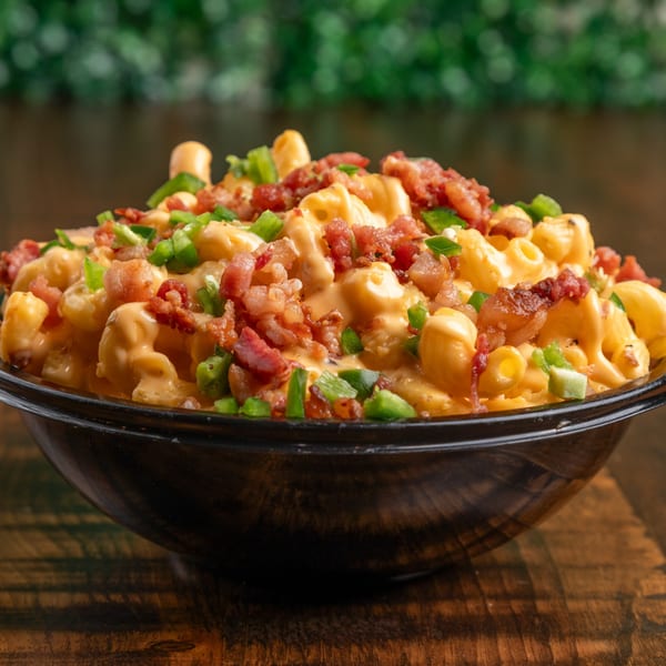 Mix & Mac Kitchen's mac and cheese with bacon and green peppers in a black bowl.
